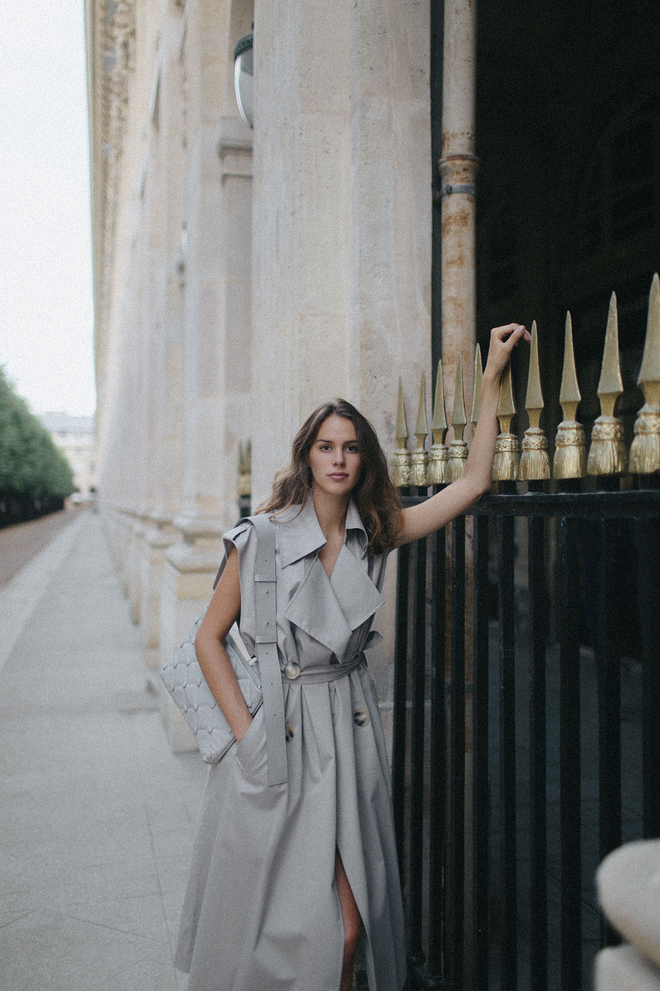 Model in trench coat with Laimushka grey leather shoulder bag in Paris, Palais Royal